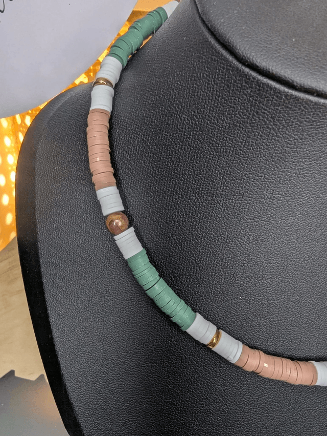 collier ras de cou avec des perles plates heishi de couleurs vert, blanc, marron et or et des perles naturelles.