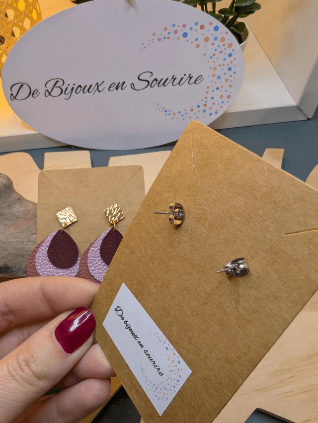 Boucles d'oreilles en cuir en forme de goutte avec un dégradé de rose/violet et le derrière est en blanc. Le fermoir en clou carré est en argent.