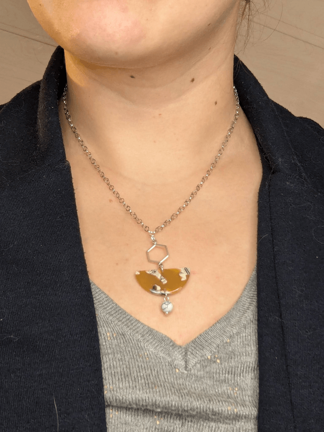 Collier mi long avec chaine couleur argent et pendentif en résine jaune et blanc, pendentif métal argenté. 