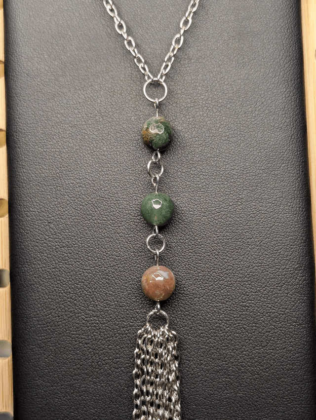 Collier long, sautoir, avec une chaine de couleur argent, perles naturelles d'agate indienne verte, et un pompon en chaine argentée.