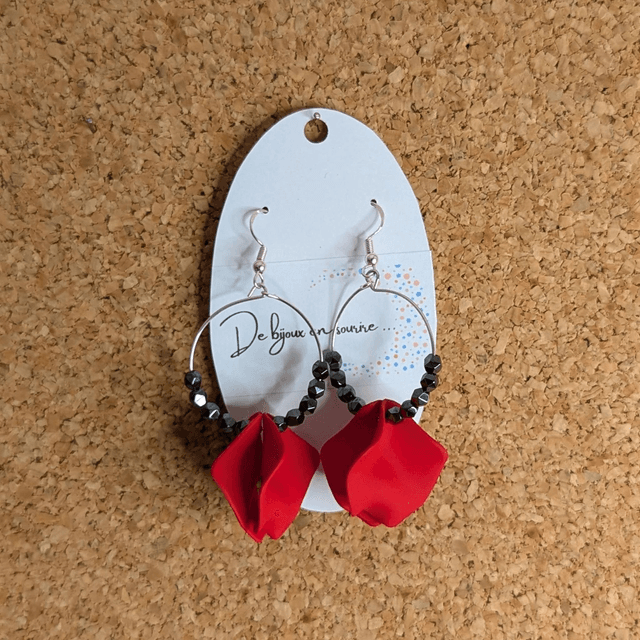Boucle d'oreille en perles naturelles d'hématite noire et des breloque en forme de pétales en acrylique rouge. 