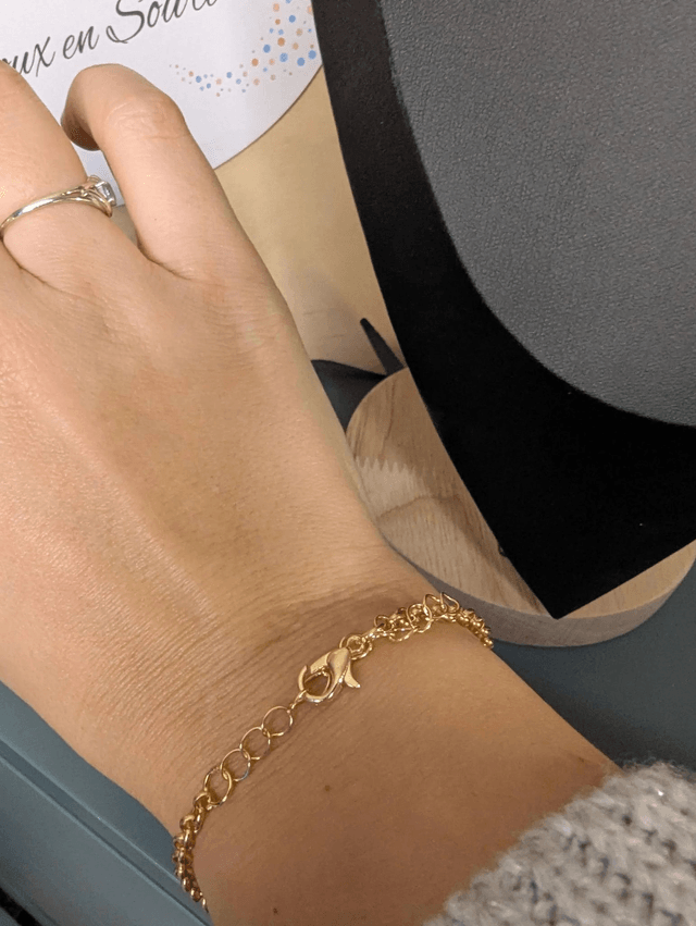 Bracelet en chaine de couleur or en forme de cœur en cuir et tissus enduit rouge, le fermoir est de couleur or. 