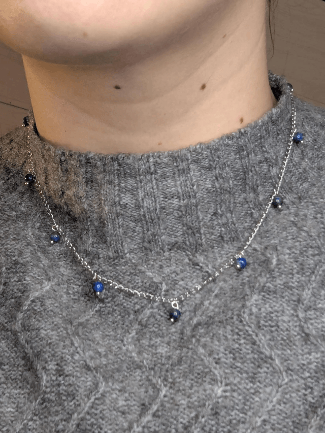 collier court chaine en argent fine et des perles naturelles de lapis lazuli de couleur bleu, la chaine fermoir est de couleur argent. 