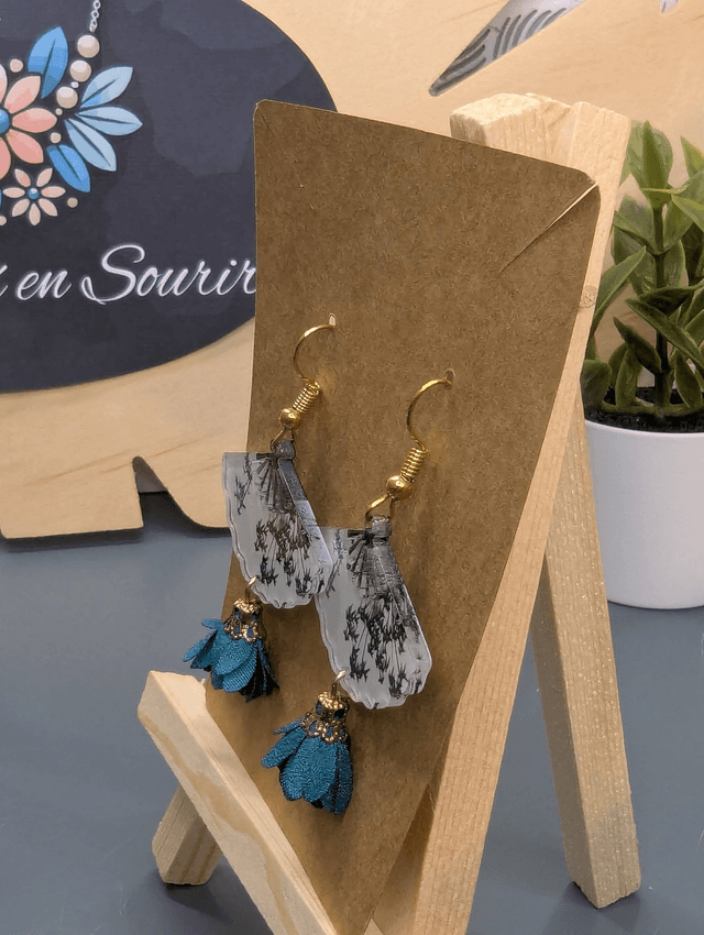 Boucles d'oreilles avec breloque éventail et pompon bleu.