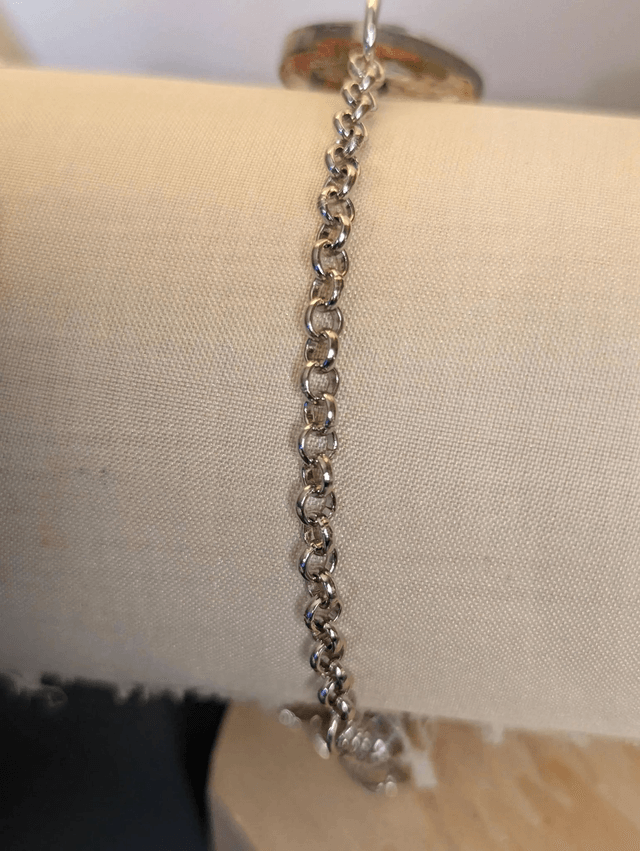  Bracelet avec une chaine de couleur argent et un pendentif en résine avec des fleurs séchés jaune, le fermoir est en argent. 