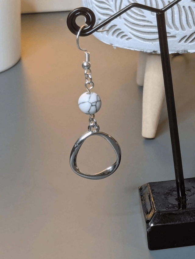 Boucles d'oreilles pendante avec des perles naturelles et un pendentif en couleur argent. Le fermoir est en argent 925.