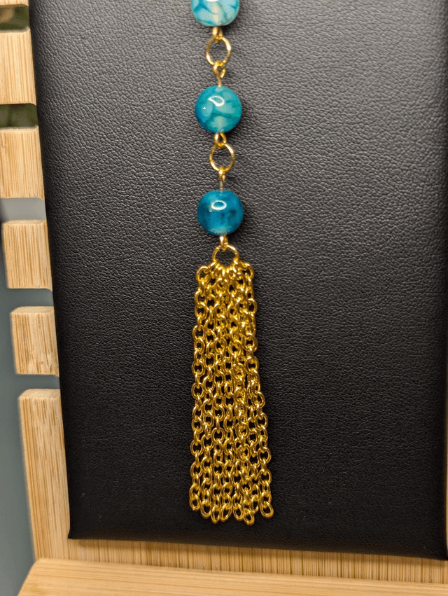 Collier long, sautoir, chaine de couleur or, avec des perles naturelles d'agate bleu-vert et un pompon en chaine doré.