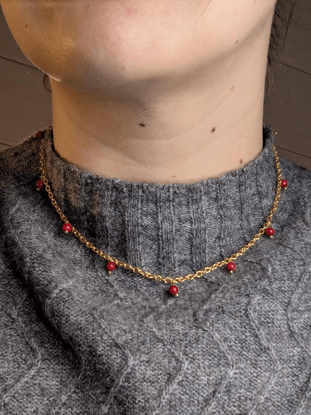 collier court chaine en or fine et des perles naturelles de couleur rouge, la chaine fermoir est de couleur or. 