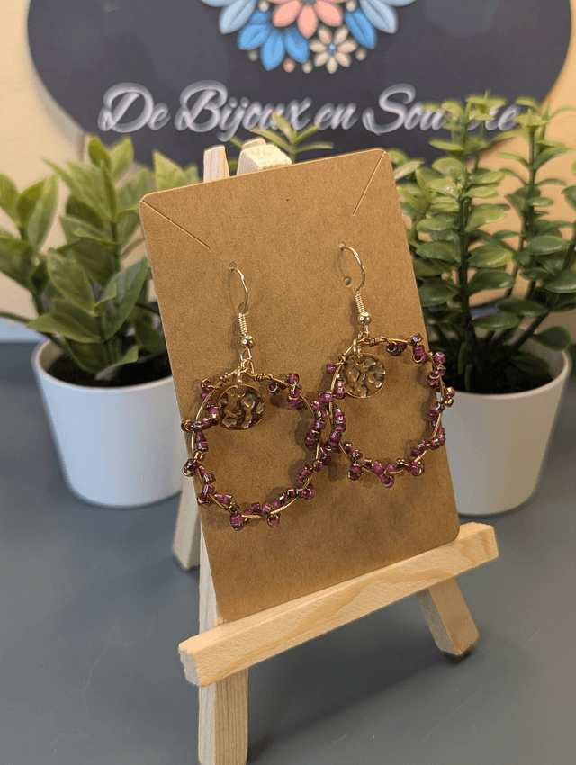 Petites créoles avec perles en verre violette et pendentif rond de couleur or. 