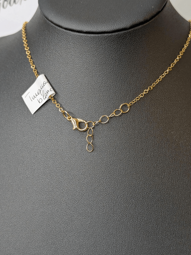 Collier mi long avec une chaine de couleur or et un pendentif en résine rose et noir et un pendentif en métal doré.