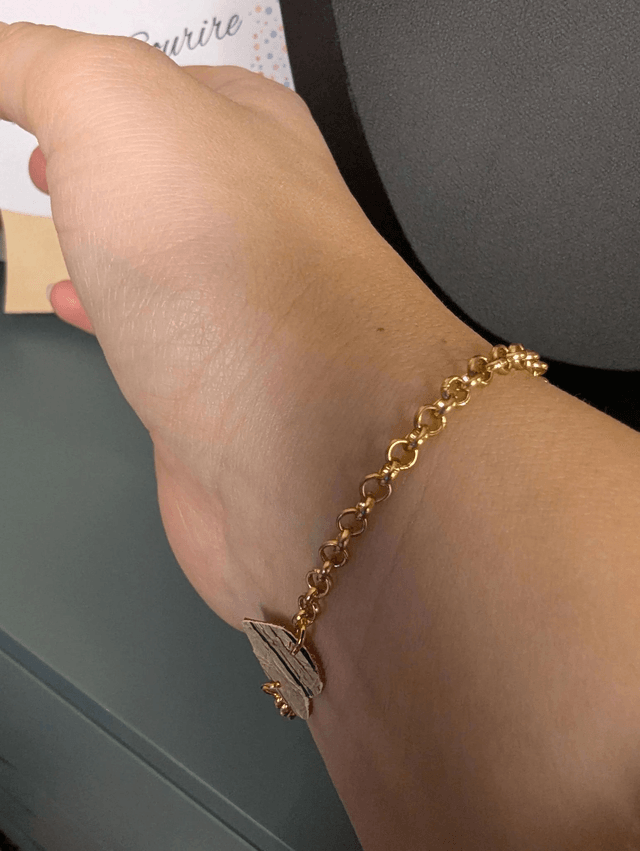 Bracelet en chaine de couleur or en forme de cœur en cuir et tissus enduit rouge, le fermoir est de couleur or. 