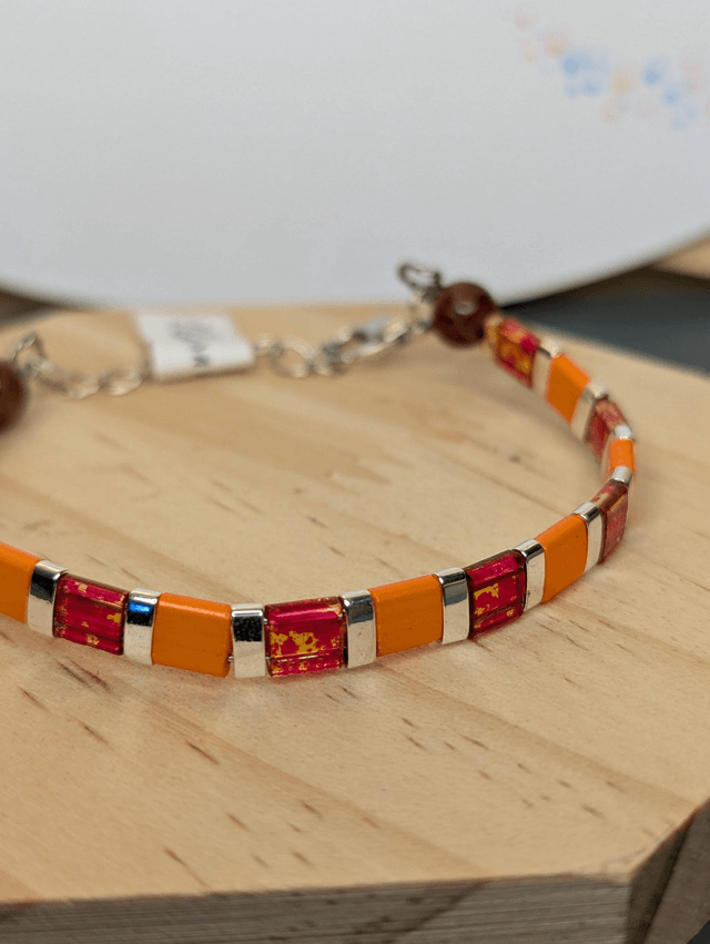 Bracelet en perles plate en verre orange et rouge, perles en métal argenté. le fermoir et la chaine fermoir sont en argent.