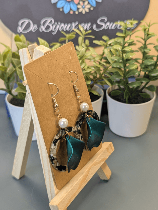 Boucles d'oreilles avec 2 pendentifs, cercle en résine coloré blanc et noir et pétale vert à l'intérieur.