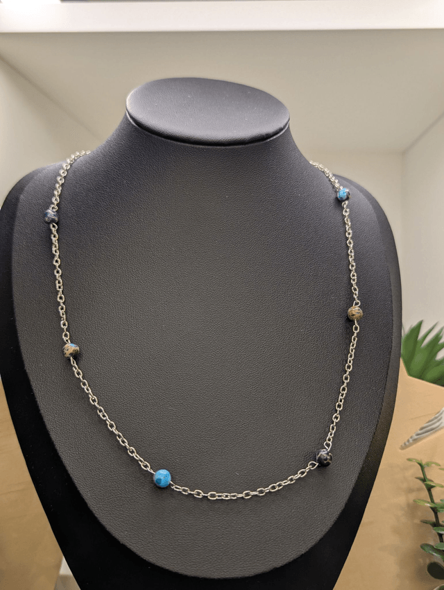 Collier mi-long avec une chaine fine en argent et des perles naturelles de jaspe de sédiment de mer. 