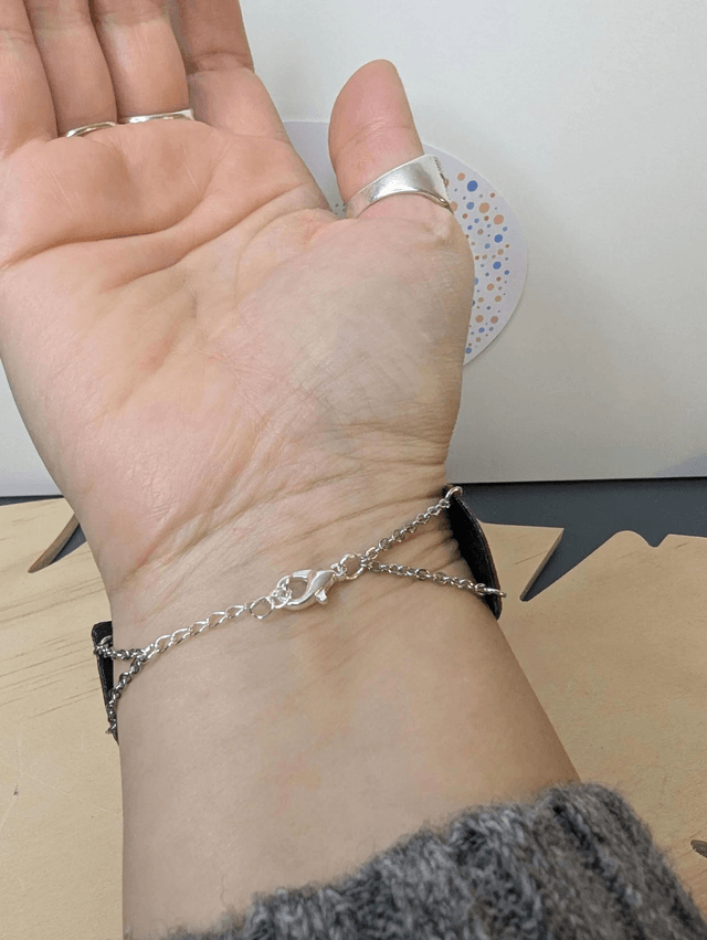 Bracelet manchette en cuir rouge Bordeau, avec du tissus enduit noir (résistant), une chaine couleur argent. le fermoir est de couleur argent.
