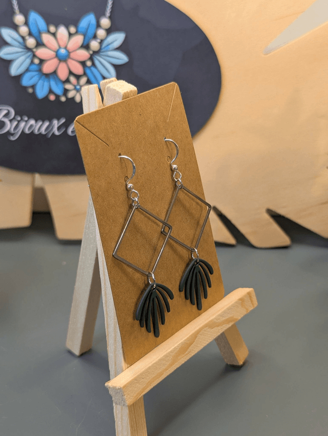 Boucles d'oreilles longue avec pendentif carré et feuille verte.
