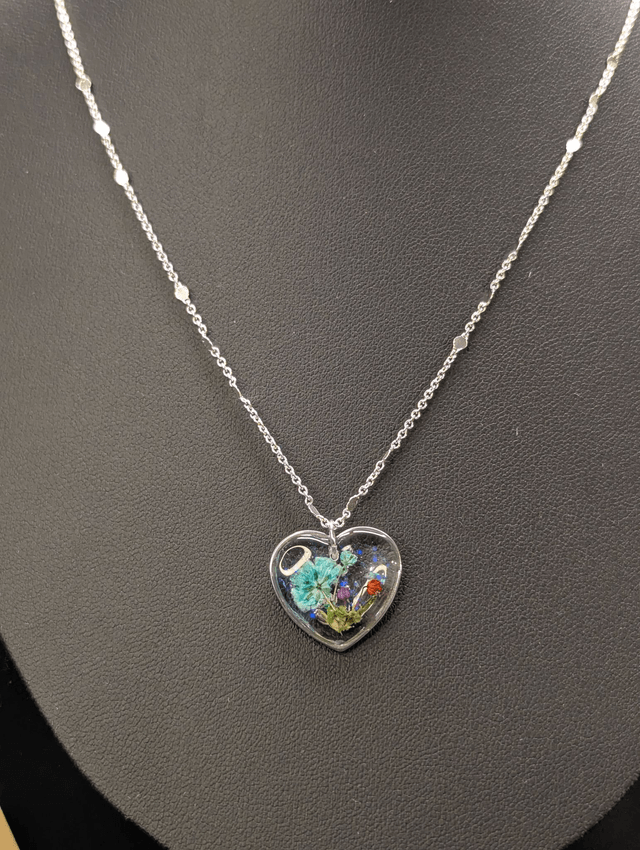 Collier avec chaine argent et pendentif en forme de cœur et fleurs séchées. 