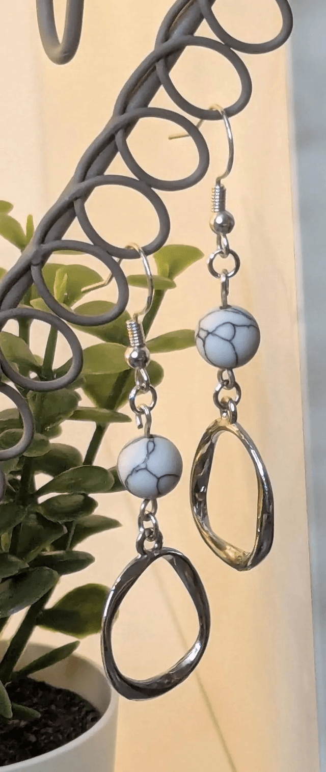 Boucles d'oreilles pendante avec des perles naturelles et un pendentif en couleur argent. Le fermoir est en argent 925.