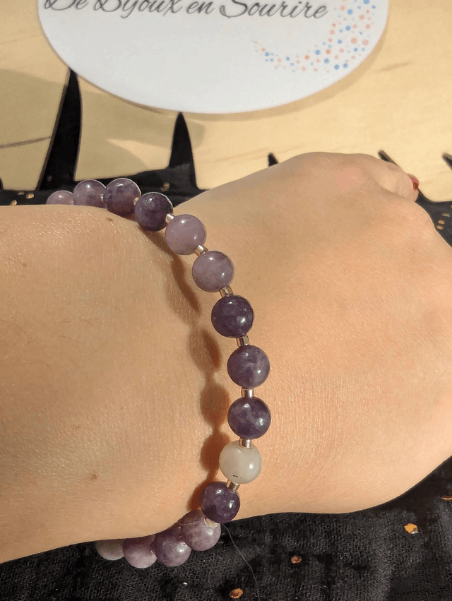 Bracelet en perles de lépidolite violette, et des perles d'espacement violette. Le fermoir et la chaine fermoir sont de couleur or.