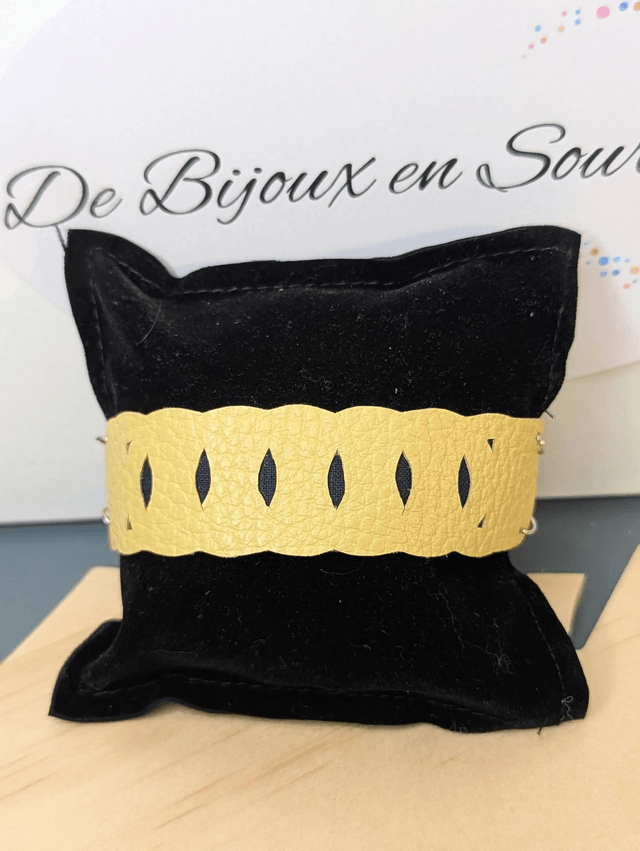 Bracelet manchette en cuir jaune, avec du tissus enduit bleu sombre (résistant), avec une chaine en argent. Le fermoir est de couleur argent.