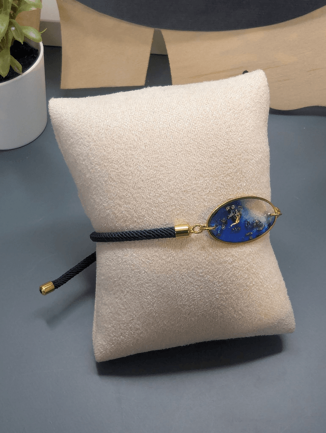 Bracelet corde ajustable bleu foncé et pendentif ovale en résine.