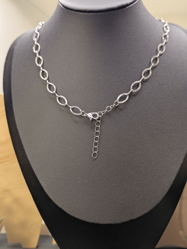 Collier avec une chaine de couleur argent et un pendentif rond  en résine bleu. 