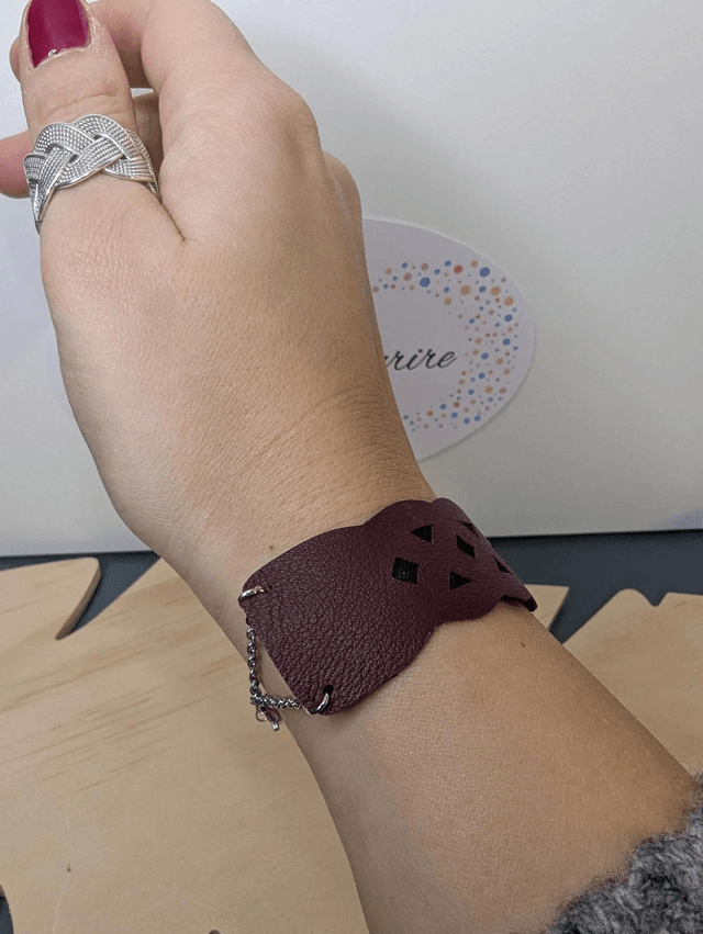 Bracelet manchette en cuir rouge Bordeau, avec du tissus enduit noir (résistant), une chaine couleur argent. le fermoir est de couleur argent.