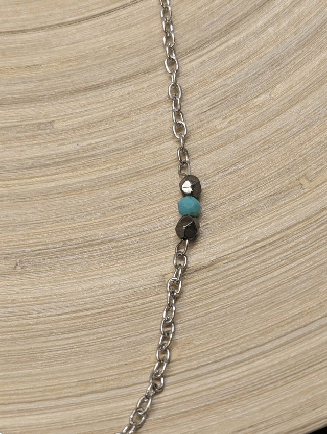 Collier long avec de la chaine couleur argent, intercalé de perles d'hématite noir et de perles colorés en verre. 