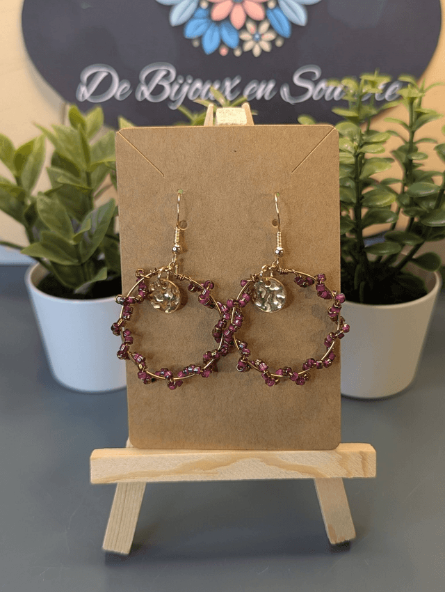 Petites créoles avec perles en verre violette et pendentif rond de couleur or. 