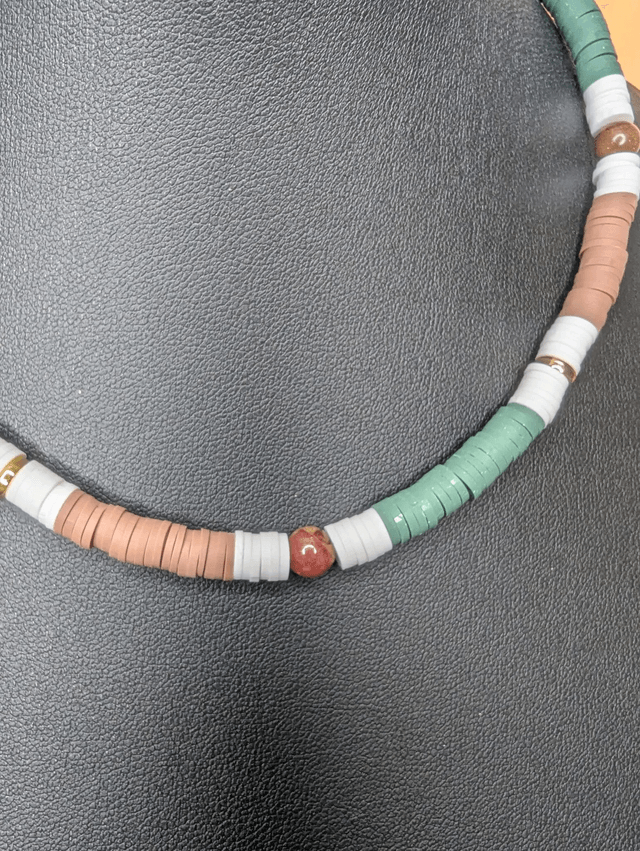 collier ras de cou avec des perles plates heishi de couleurs vert, blanc, marron et or et des perles naturelles.