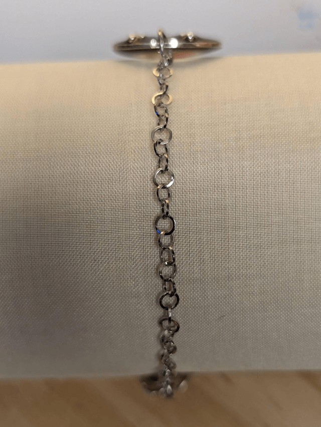 Bracelet avec une chaine en argent, un pendentif en résine noir, avec des fleurs séchés rouge, le fermoir est en argent.