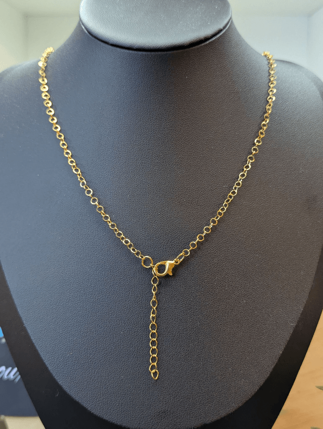 collier mi long de couleur or avec un pendentif en résine rouge et fleur naturelle blanche. 
