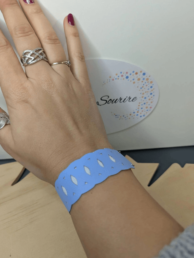 Bracelet manchette en cuir bleu lisse, avec du tissus enduit blanc (résistant), une chaine couleur argent. Le fermoir est de couleur argent.