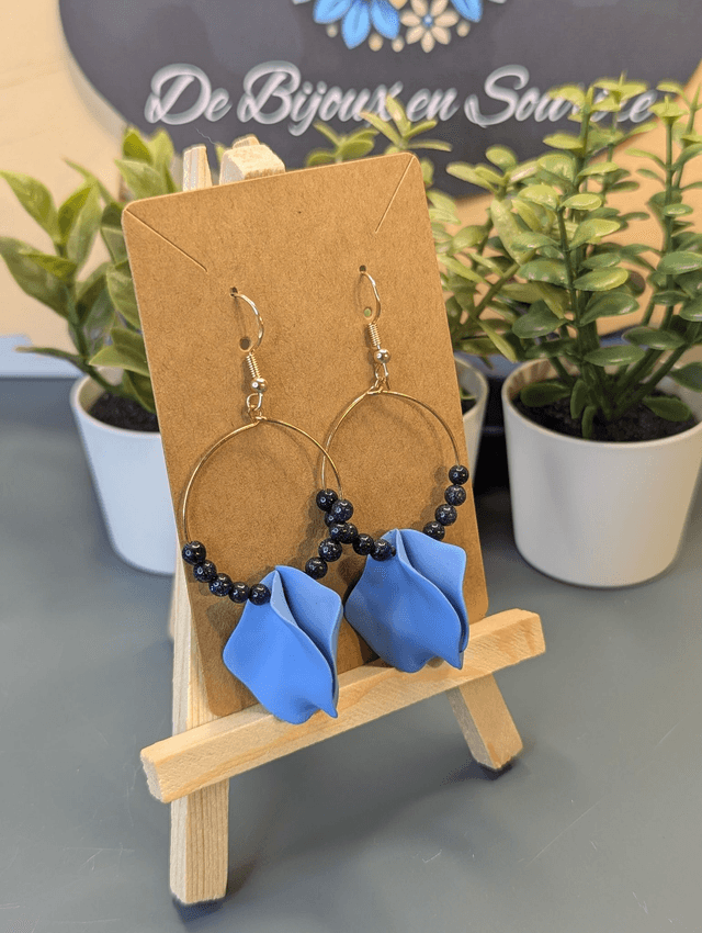 Petites boucle d'oreille créole en perles naturelles noire et des breloque en forme de pétales bleu. 