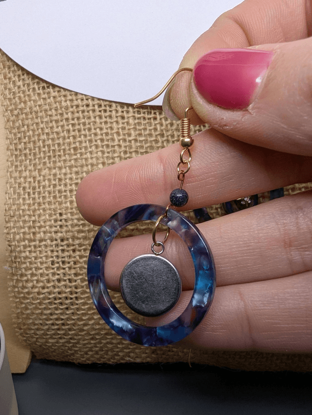 Boucles d'oreilles avec 2 pendentifs, cercle en résine coloré bleu violet, avec des fleurs séchées, des perles naturelle et un fermoir en or. 
