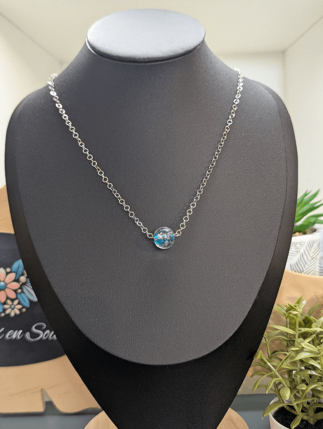 collier mi long avec chaine de couleur argent et pendentif en verre de couleur bleu clair. 
