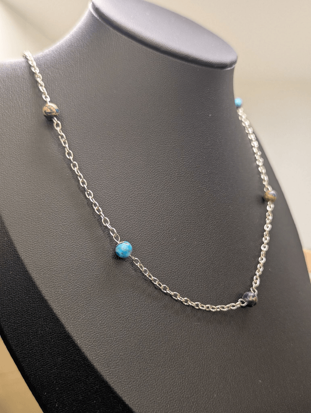 Collier mi-long avec une chaine fine en argent et des perles naturelles de jaspe de sédiment de mer. 