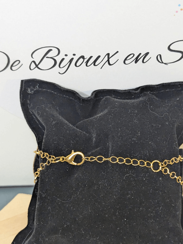 Bracelet manchette en cuir marron clair, avec du tissus enduit noir (résistant), une chaine dorée. Le fermoir est de couleur or.