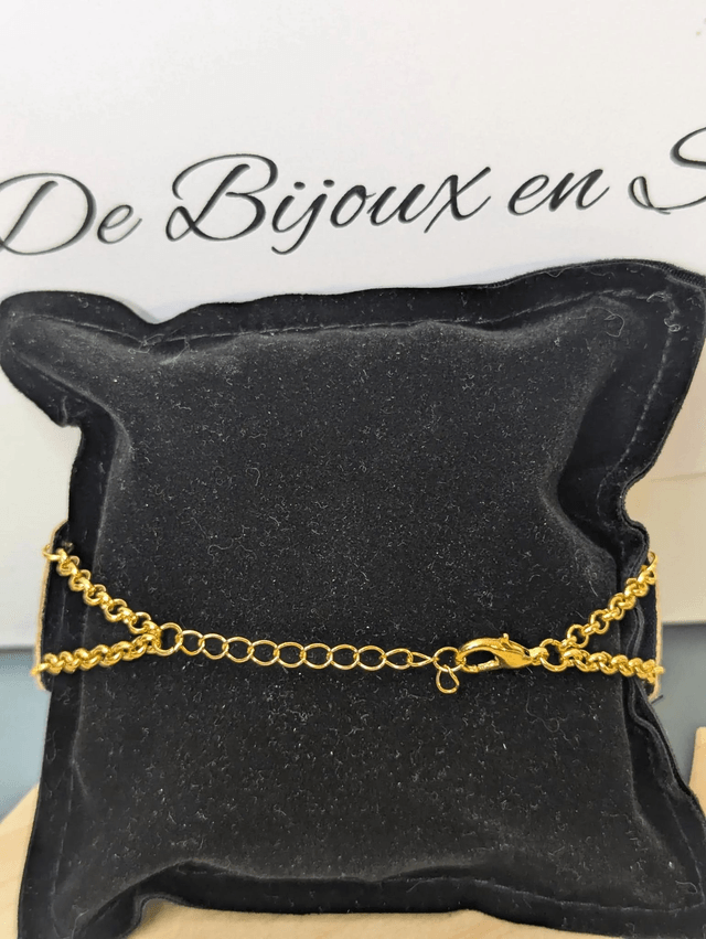 Bracelet manchette en cuir jaune, avec du tissus enduit bleu sombre (résistant), une chaine couleur or. Le fermoir est de couleur or.