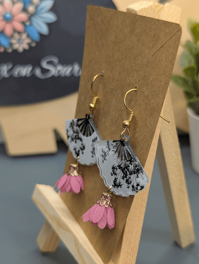 Boucles d'oreilles avec breloque éventail et pompon rose.