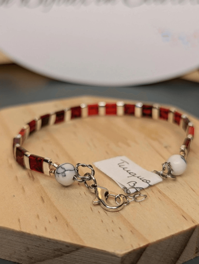 Bracelet en perles plate en verre rouge, perles d'espacement en métal argenté. le fermoir et la chaine fermoir sont en argent. 