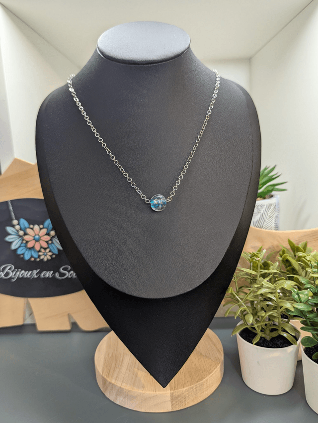 collier mi long avec chaine de couleur argent et pendentif en verre de couleur bleu clair. 