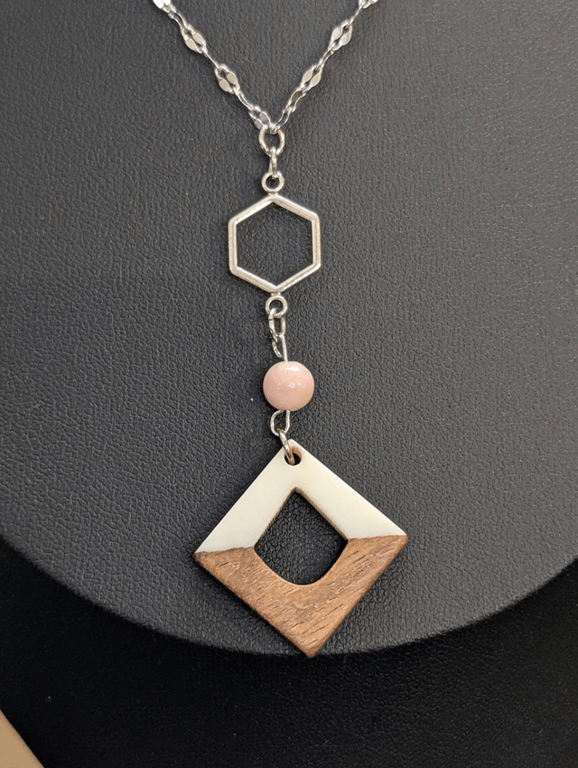 Collier long, sautoir, avec une chaine de couleur argent, perle naturelle, un pendentif en métal et pendentif en bois.