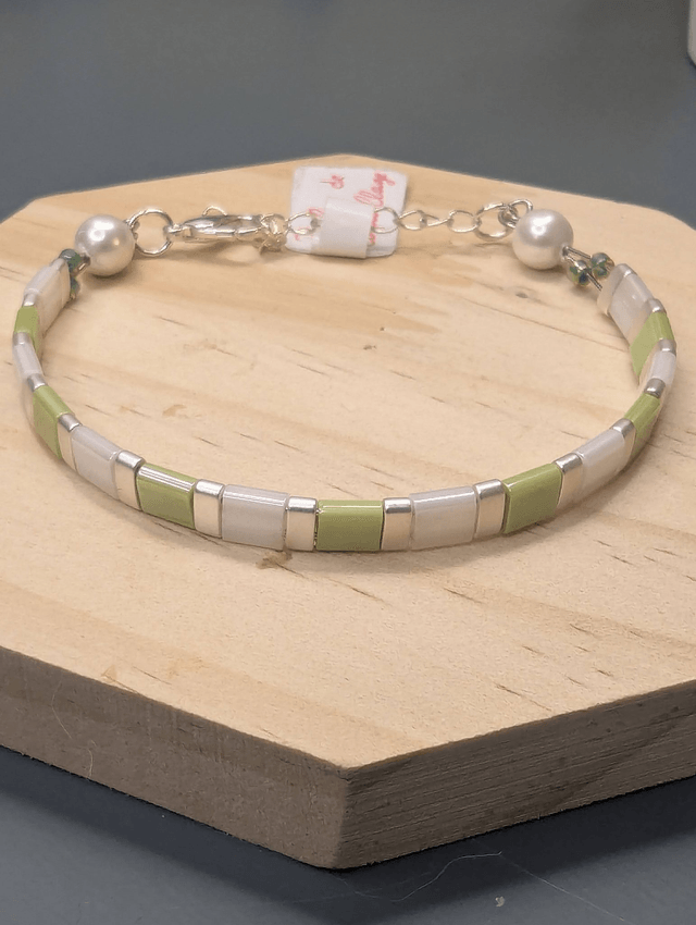 Bracelet en perles plate en verre blanc et vert clair avec des perles d'espacement en métal argenté. Le fermoir et la chaine fermoir sont en argent.