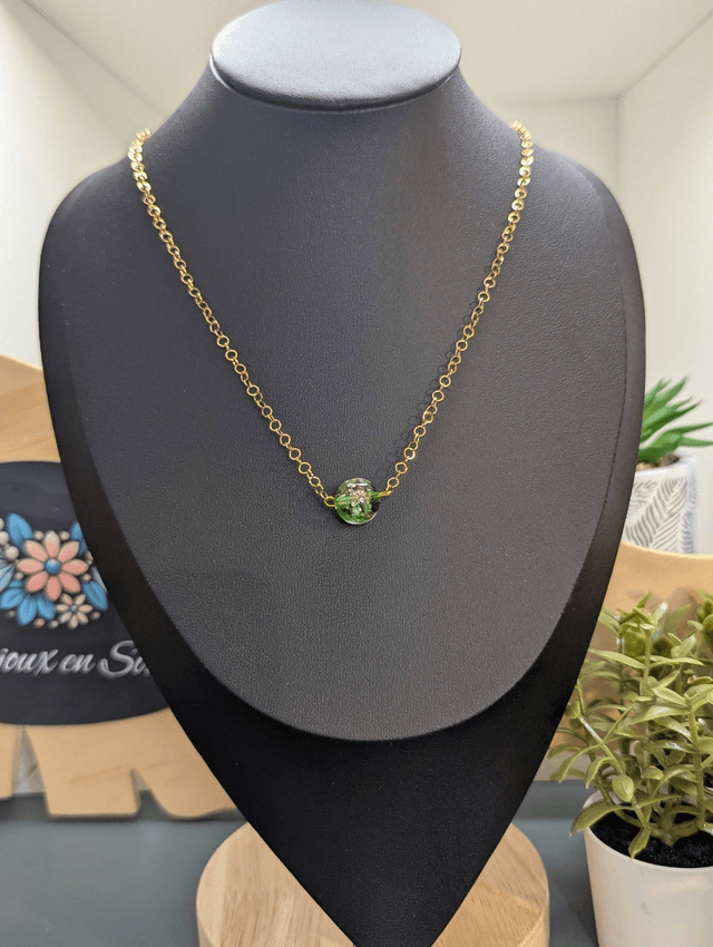 collier mi long avec chaine de couleur or et pendentif en verre de couleur vert foncé. 