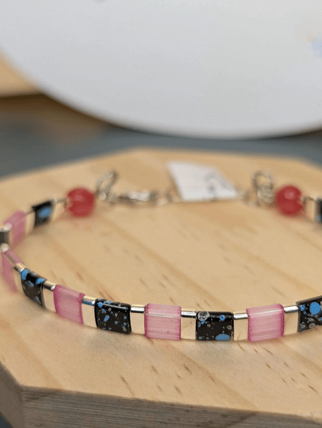 Bracelet en perles plate en verre rose et noire, avec des perles en métal argenté. Le fermoir et la chaine fermoir sont en argent.