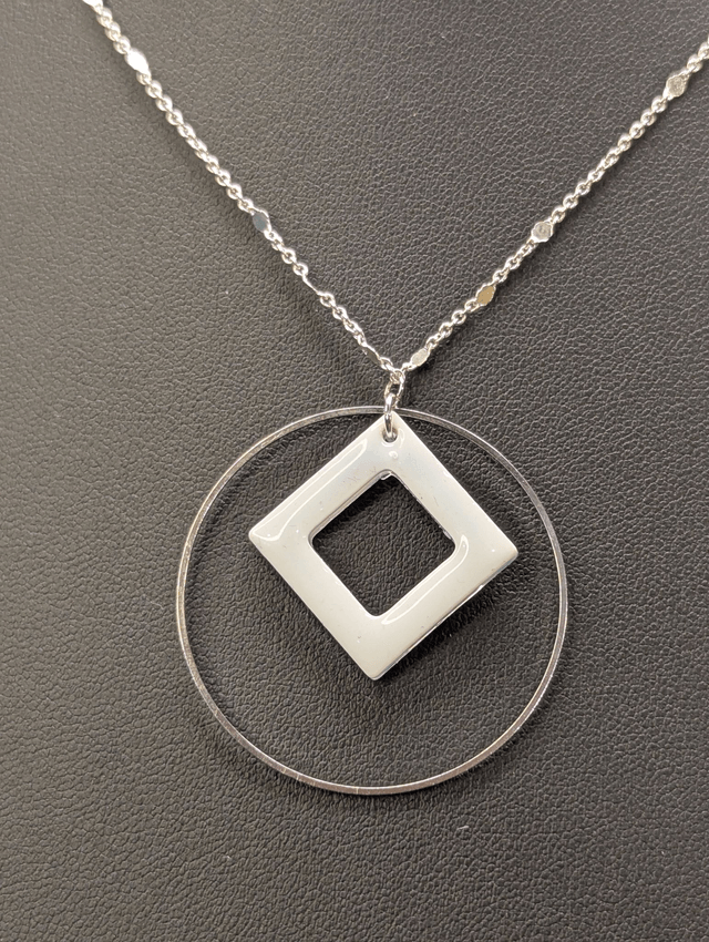 Collier court avec une chaine de couleur argent, un pendentif avec carré en résine et un cercle en métal argenté. 