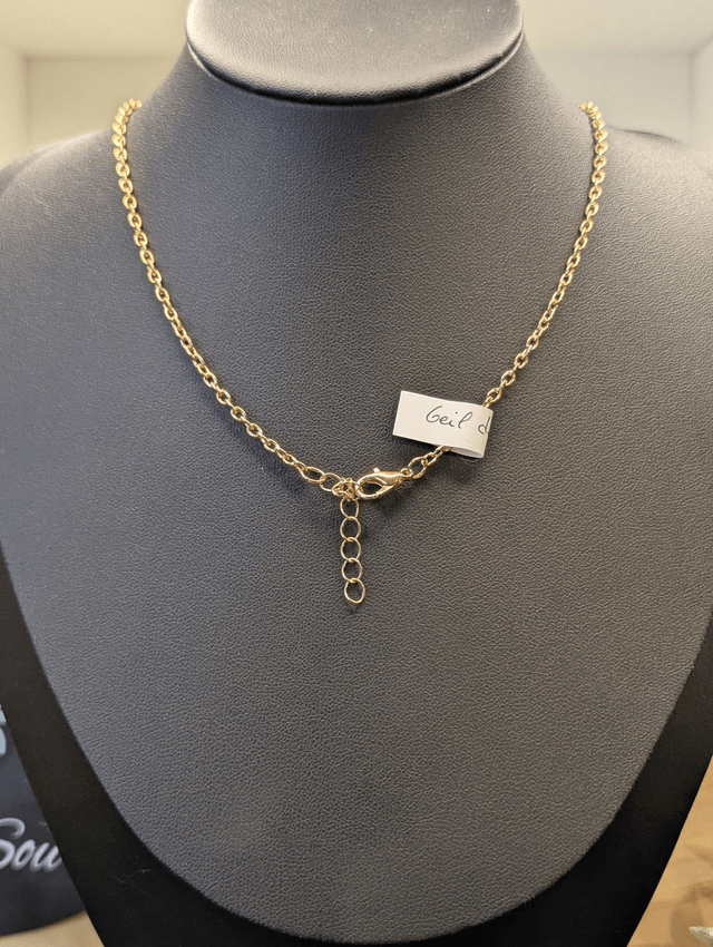 Collier mi long avec une chaine de couleur argent, un pendentif en résine noire et gris pailleté et des perles naturelles rose. 