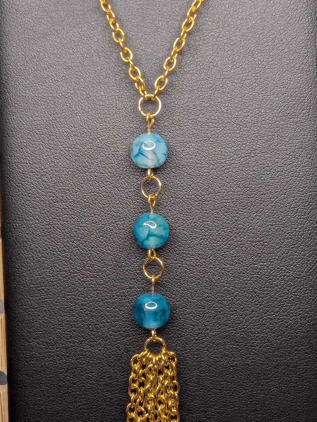 Collier long, sautoir, chaine de couleur or, avec des perles naturelles d'agate bleu-vert et un pompon en chaine doré.
