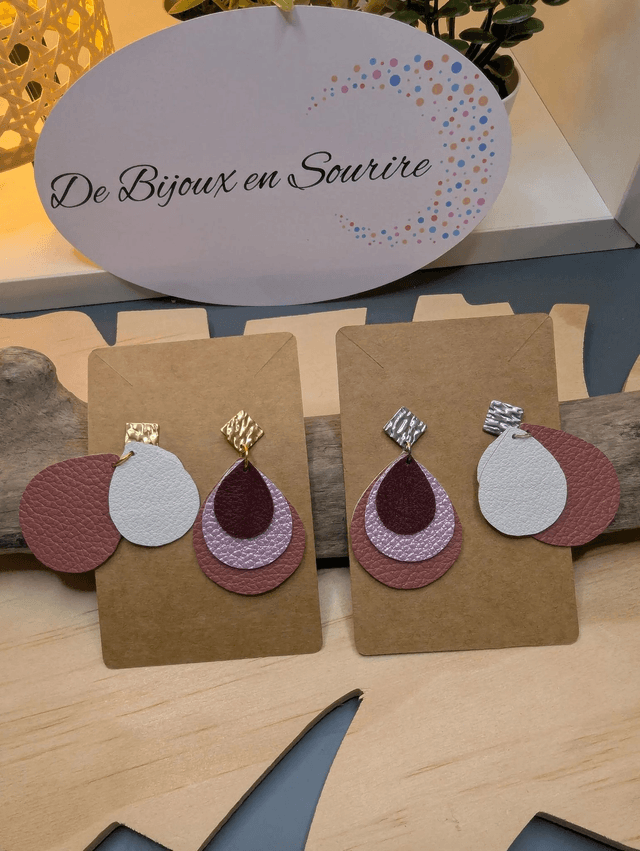 Boucles d'oreilles en cuir en forme de goutte avec un dégradé de rose/violet et le derrière est en blanc. Le fermoir en clou carré est en argent.